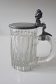 Nisse ølkrus i glas med låg af tin.