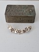 Vintage silver brooch shaped like a vine with flowers and leaves