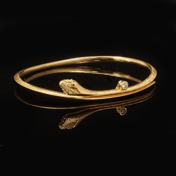 Ole Lynggaard Snakes armring. Oplukkelig oval armring i 18kt guld prydet med i 
alt 5 brillanter på i alt ca. 0,06ct. Stemplet Ole Lynggaard. Indvendige mål: 
5,9x4,8cm